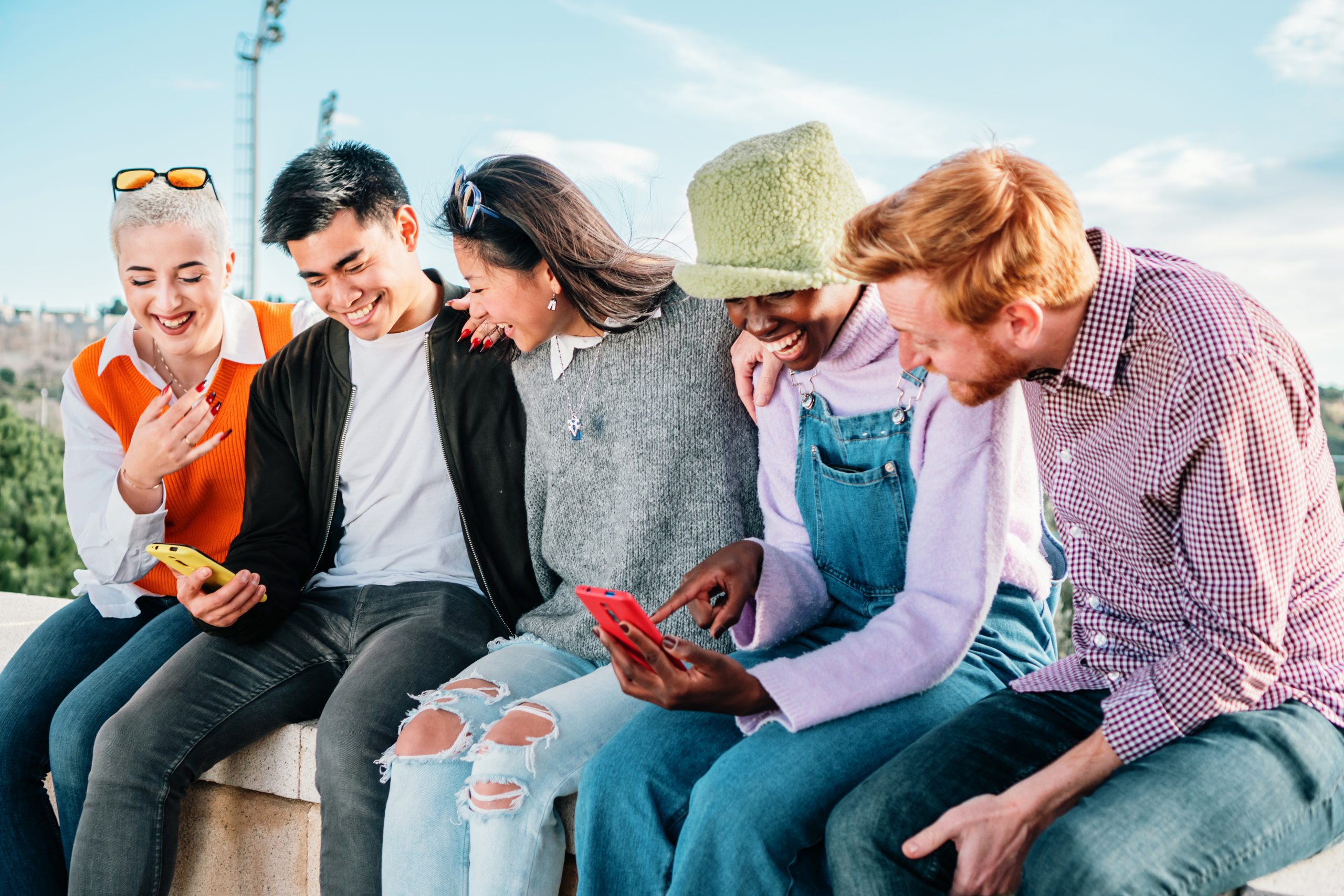 Five multiracial friends watching videos in social media sitting together and having fun. high quality photo